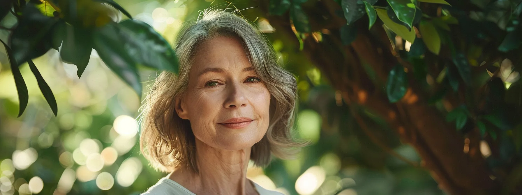 a graceful older woman showcases an elegant bob hairstyle, framed by soft, natural sunlight filtering through lush greenery, exuding confidence and timeless beauty.